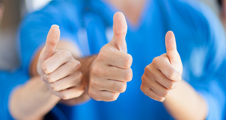 Three Wilmington dental team members giving thumbs up